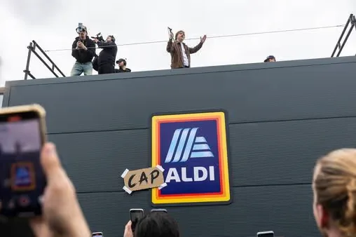 Lewis Capaldi on the roof of an Aldi store with the sign rebranded Cap-Aldi, shoppers filming from below