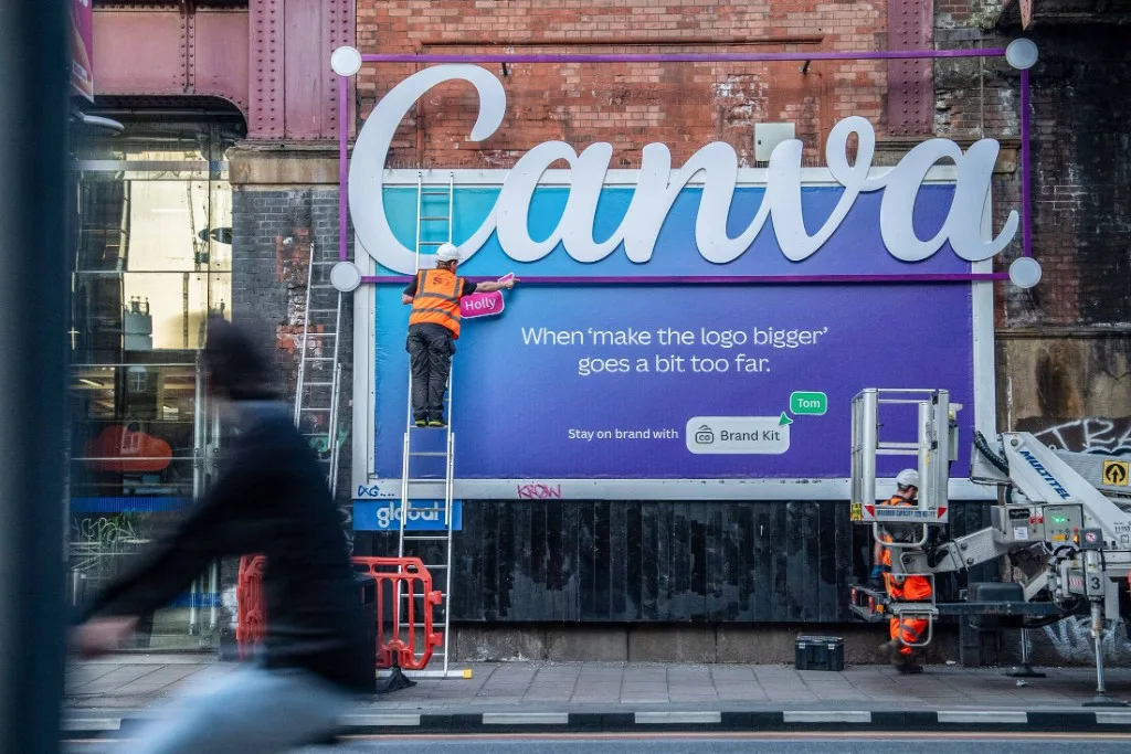 Canva billboard with an oversized logo breaking out of the frame and the line 'When make the logo bigger goes a bit too far', a recent innovative marketing example in OOH