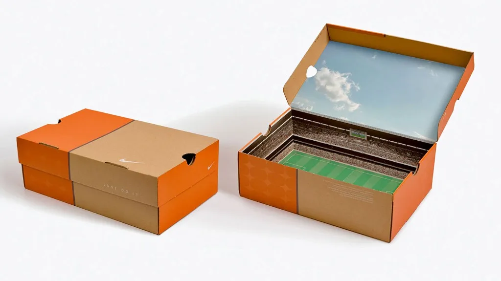 Nike 'Stadium' shoebox direct mail that opens to reveal a miniature football stadium with stands, a green pitch, and a sky-and-clouds lid